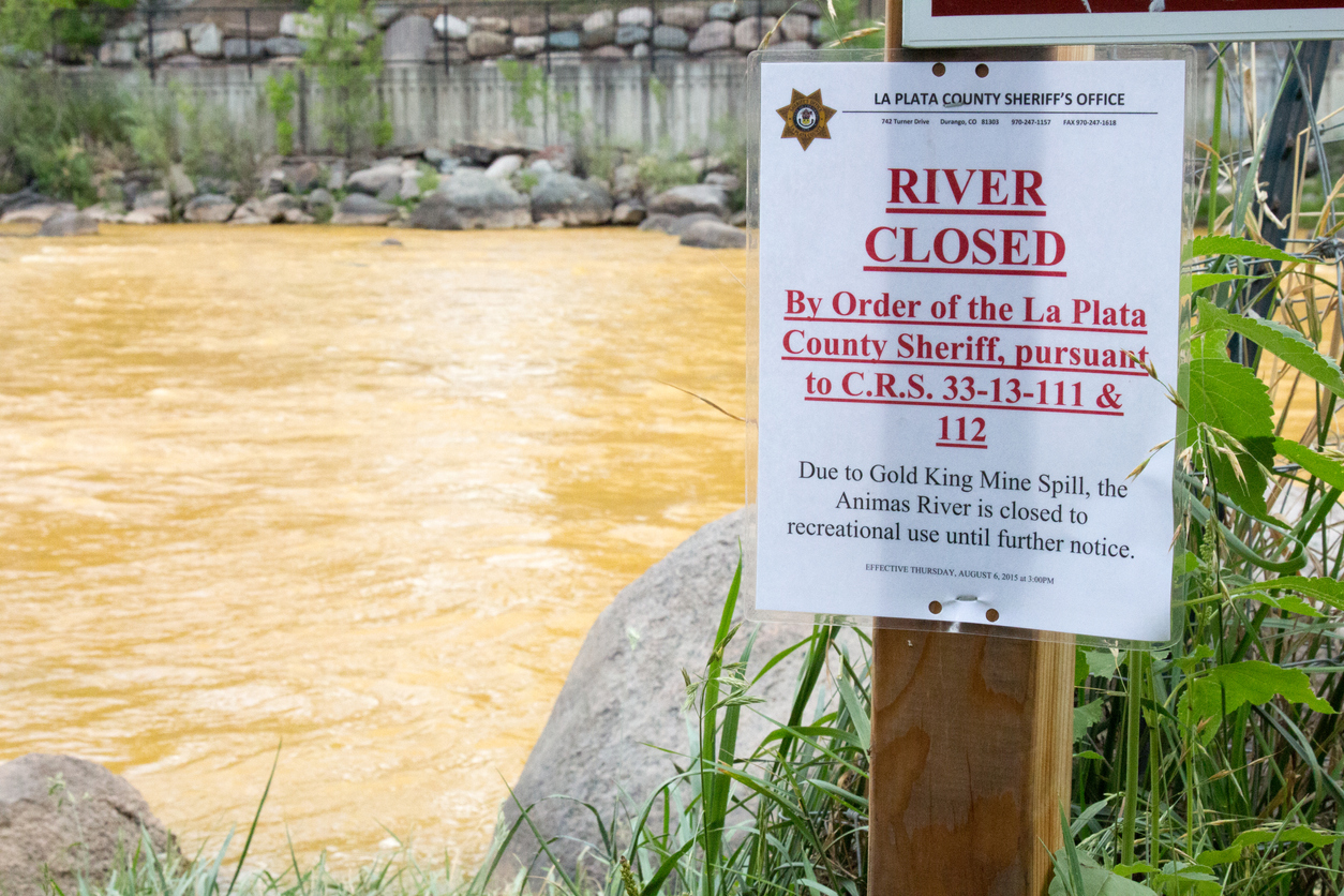 Durango, CO, USA - August 7, 2015: Sign posted on the orange hued Animas River in Durango, Colorado that says the river is closed due to the Gold King Mine Spill that poured toxic waste into the river. Restorative Justice can best address animals